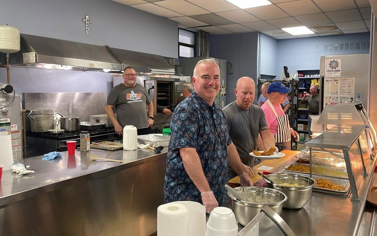 Men's Club volunteers working the serving line in the Holy Name cafeteria kitchen